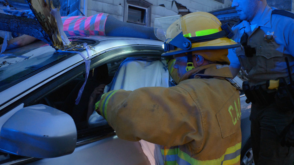 Firefighter uses a FoxFury Command helmet light for task illumination during an auto extrication